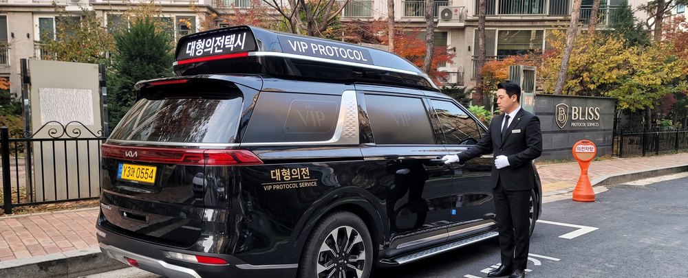 정장 차림 기사가 문을 여는 VIP 의전 장면